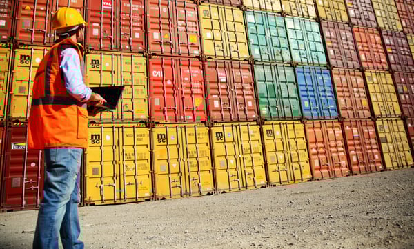 Construction worker and stacked metal containers